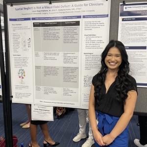 A student standing with her research poster