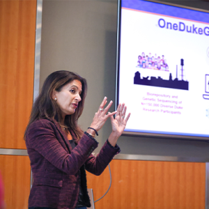 Svati Shah presenting to a screen that says OneDukeGen initiatives