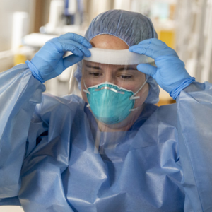 Healthcare provider donning PPE in a clinical setting