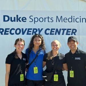 four Duke DPT students at the Duke Sports Medicine recovery tent