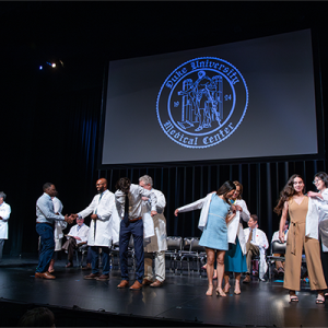 Students receiving their white coats at the SoM MD program white coat ceremony. 