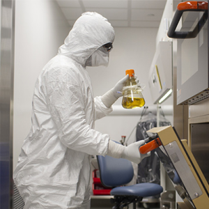 A person wearing protective equipment working in a lab.