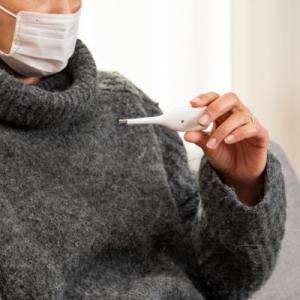 Stock photo of woman holding thermometer