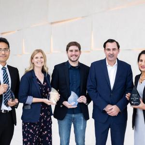 5 people standing and holding awards