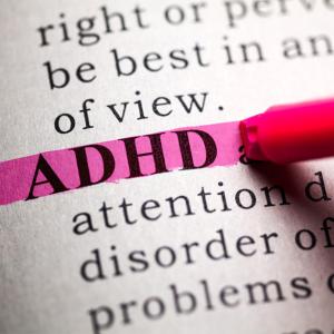 A pink highlighter highlights the word ADHD in a page of text.