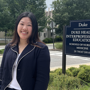 Phoebe standing next to the sign for Duke IPE building that houses the OTD program