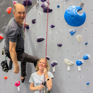 Joel and Caroline Graybeals on a rock climbing wall.