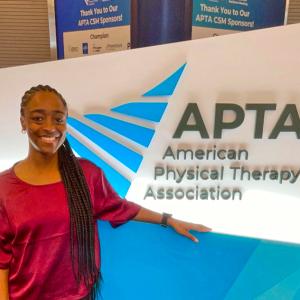 Cierra posing by an APTA sign