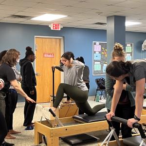 people using physical therapy equipment while students look on
