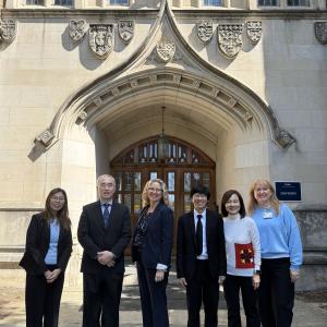 Group of six people standing in front of a building entrance