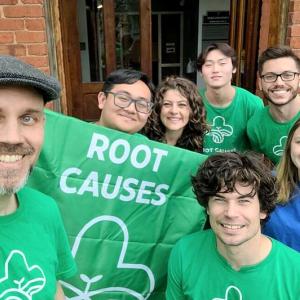 A group of students with a root causes banner.
