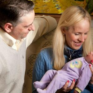 Sabrina Lewandowski holds her baby girl, Layla, while her husband, Greg, looks on