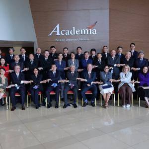 Image: A group of professionally dressed individuals in suits and ties posing together for a formal photograph.