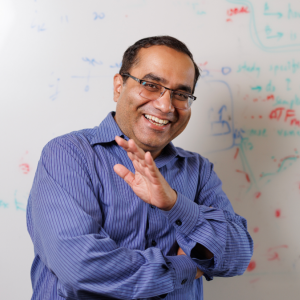 Rohit Singh, PhD, laughing in front of a whiteboard