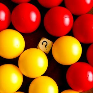 Red and yellow balls with square that has a question mark in middle