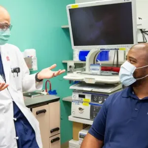 A provider in a white coat talks with a patient