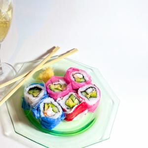 Image of sushi, wine, and chopsticks