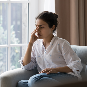 woman sitting on a sofa looking tired