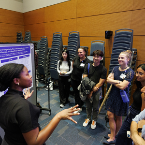 Miriam Chisholm, MS4, explains her research in front of her poster. 