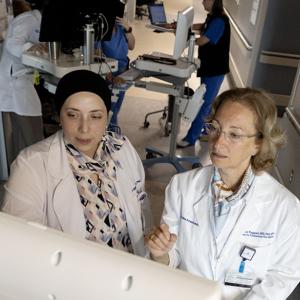 Ruba Sajdeya and Miriam Treggiari look at a computer monitor in a lab
